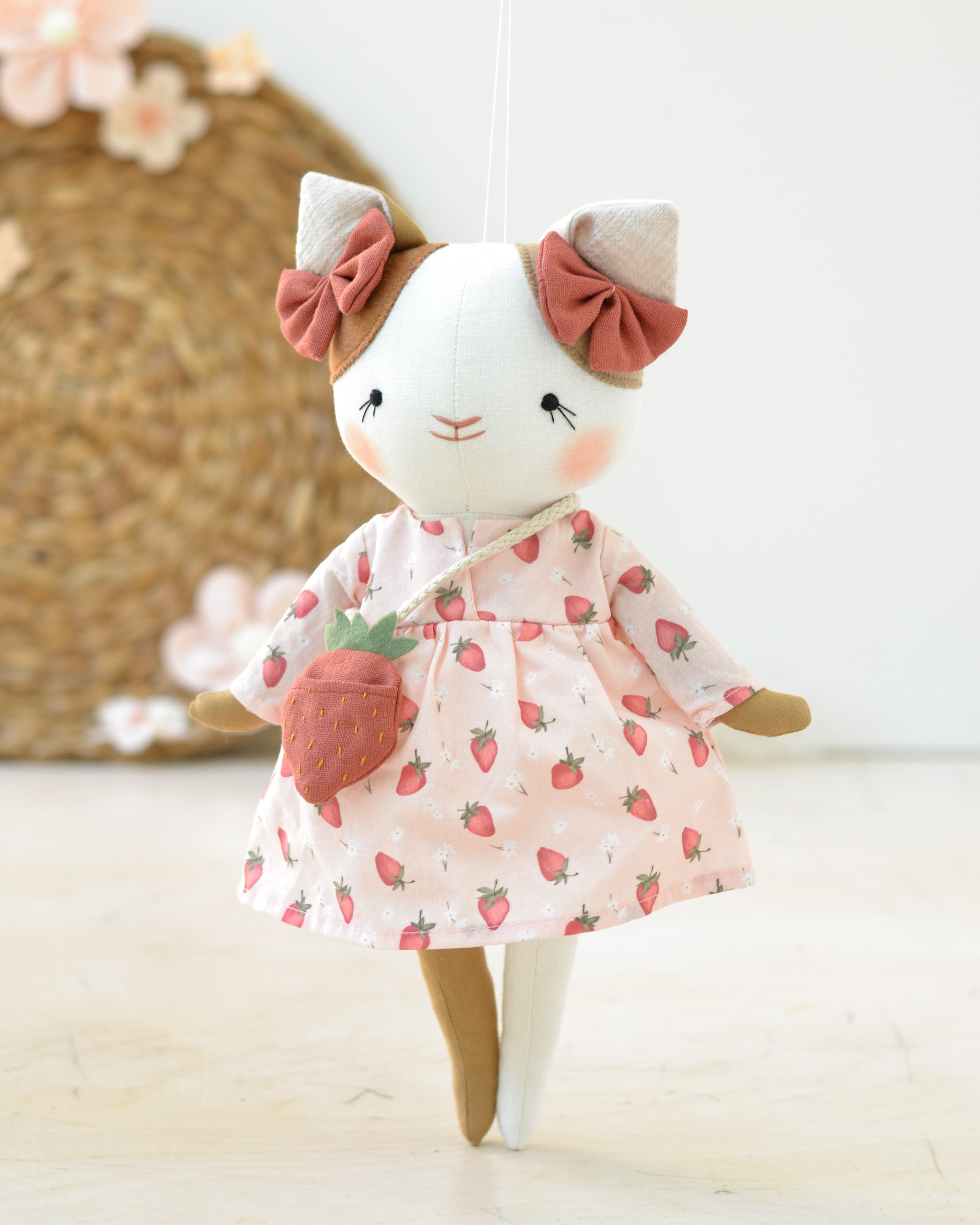 Gato de peluche Lucie con vestido blanco y bolsa de fresas